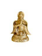Golden Garud Dev statue in a prayerful pose on an ornate pedestal
