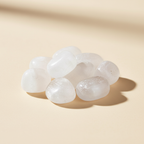 Polished Selenite tumble stones arranged on an ivory studio background