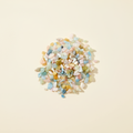 Natural pastel Beryl tumbled crystal chips arranged on an ivory background