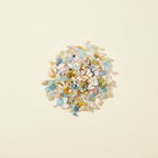 Natural pastel Beryl tumbled crystal chips arranged on an ivory background
