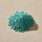 Chrysocolla Crystal Chips arranged on a warm neutral stone surface