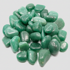 Close-up of polished green aventurine tumble stones on a light neutral background