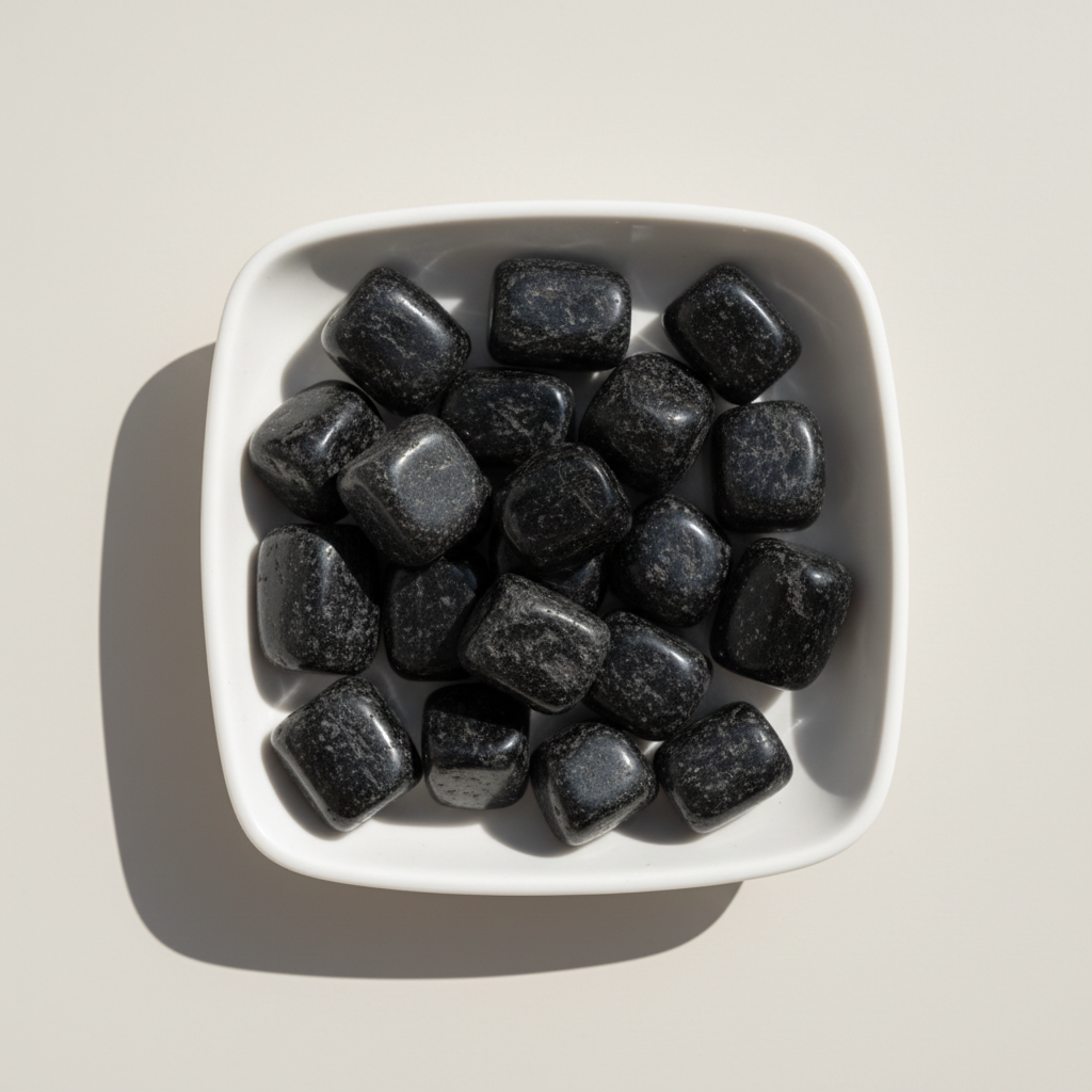 Black Tourmaline tumble stones arranged in a white ceramic dish