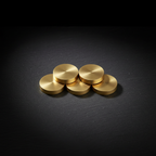Compact cluster of round gold-toned pieces on a dark stone surface with a black studio background