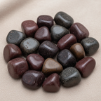 Close-up of smooth polished Red Agate tumble stones with deep red and smoky banding
