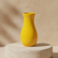 Bright yellow vase displayed on a light stone pedestal