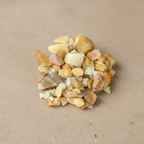 Yellow Jade Crystal Chips arranged on a warm neutral stone surface