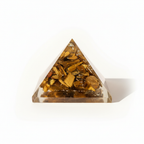 Front view of a Tiger Eye crystal pyramid on a warm white background
