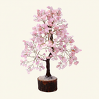 Rose Quartz crystal tree with soft pink chips, dark trunk, and natural wood base on an ivory background