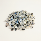 Close-up pile of Rainbow Moonstone crystal chips on a light background