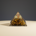 Golden-brown Tiger Eye crystal pyramid on a premium studio background