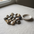 Polished Sulemani tumble stones arranged on a neutral linen surface