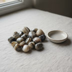 Polished Sulemani tumble stones arranged on a neutral linen surface