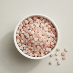 Rose Quartz crystal chips arranged in a white ceramic dish