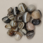 Close-up of smooth polished Sulemani tumble stones with natural layered banding