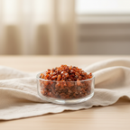 Orange and red Carnelian crystal chips displayed in a glass dish in a warm home setting