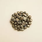 Polished Pyrite tumble stones arranged on an ivory studio background