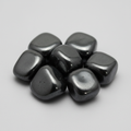 Close-up of polished hematite tumble stones on a light-gray background