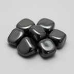 Close-up of polished hematite tumble stones on a light-gray background