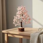 Rose Quartz crystal tree displayed on a wooden table in a calm warm bedroom or meditation space