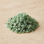 Green Aventurine Crystal Chips arranged on a warm neutral stone surface