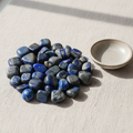 Polished Lapis Lazuli tumble stones arranged on a neutral linen surface