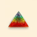 Colorful 7 Chakra crystal coil pyramid with central coil detail on a warm ivory background