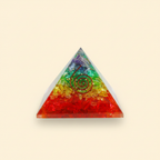 Colorful 7 Chakra crystal coil pyramid with central coil detail on a warm ivory background