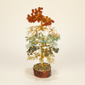 Multi-Color crystal tree with layered orange, cream, pale green, and deep green stones on an ivory background