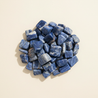 Polished Sodalite tumble stones arranged on an ivory studio background