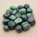 Close-up of smooth polished Ruby Zoisite tumble stones with green matrix and red inclusions