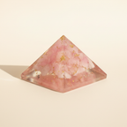 Side profile of a soft pink Rose Quartz crystal pyramid with faceted detail