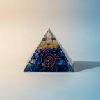 Lapis Lazuli crystal pyramid displayed on a soft blue and cream background