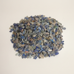 Small natural pile of Lapis Lazuli Chips on a warm studio surface