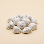Polished Howlite tumble stones arranged on an ivory studio background