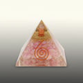 Pink crystal pyramid with a gold top detail and copper spiral on a premium studio background