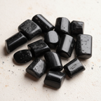 Close-up arrangement of Black Tourmaline tumble stones on a light background