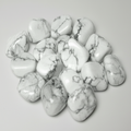 Close-up of polished Rainbow Moonstone tumble stones on a light neutral background