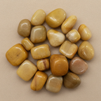 Close-up of smooth polished Yellow Jade tumble stones with warm golden mottling
