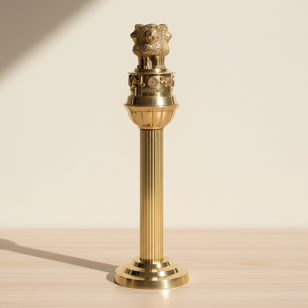 Tall brass Ashoka Pillar-inspired decor displayed on a warm neutral surface