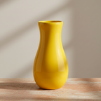 Bright yellow vase on a warm terracotta and cream stone surface