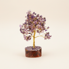 Amethyst crystal tree with purple chips, golden branches, and wood base on an ivory background