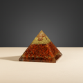Rich red jasper crystal pyramid on a premium studio background