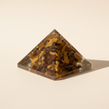 Side profile of a Tiger Eye crystal pyramid with warm golden-brown detail