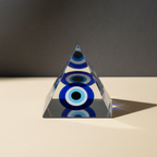 Blue-and-white Evil Eye protection pyramid on a premium studio background