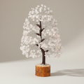 Clear Quartz crystal tree with translucent white chips, dark branches, and a wood base on a neutral background