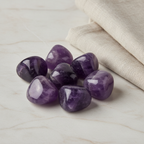 Amethyst tumble stones arranged with neutral linen décor