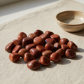 Polished Red Jasper tumble stones arranged on a neutral linen surface