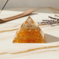 Golden Citrine crystal pyramid displayed on an elegant neutral surface