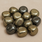 Close-up of smooth polished Pyrite tumble stones with warm metallic reflective surfaces